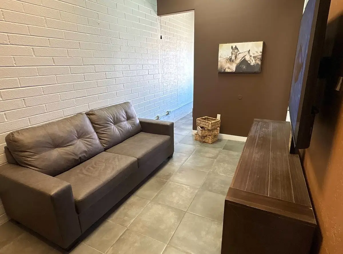Customer lounge with a brown leather sofa, wood bench and horse artwork